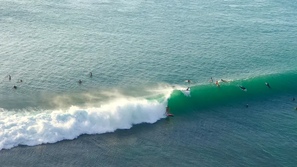Surfers on a reef wave in South Kuta district, Bali