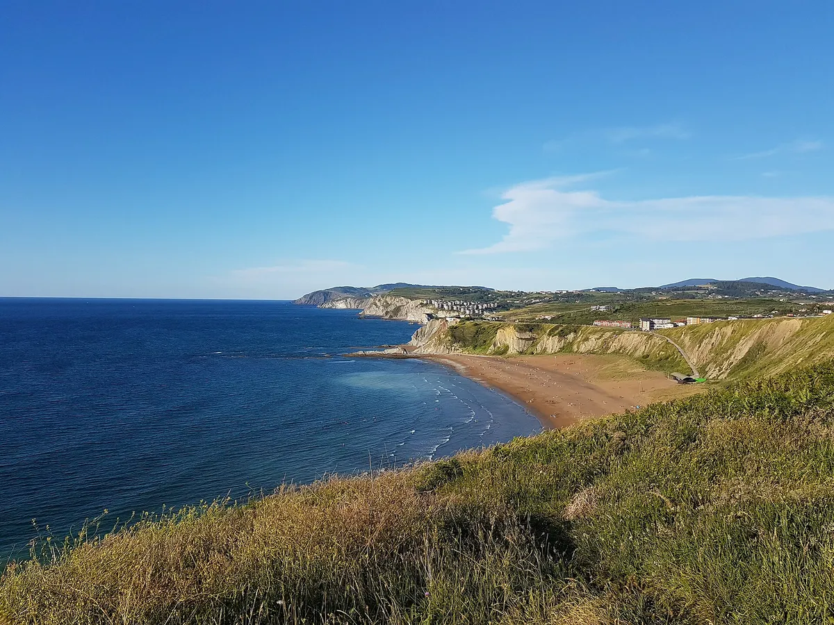 Vista elevada de la playa de Barinatxe, con el mar a la izquierda y la costa al fondo