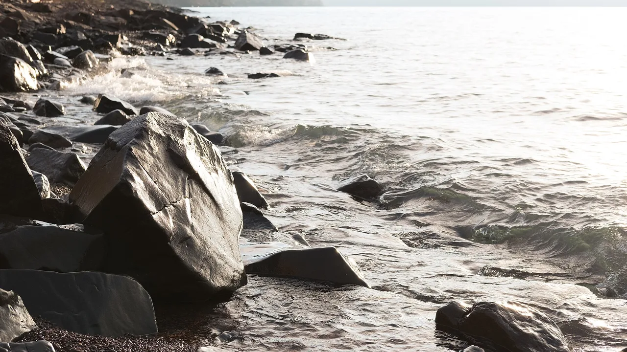 Waves rolling into the rocky North Shore at Brighton Beach, Duluth, Minnesota, backlit by morning light on Lake Superior