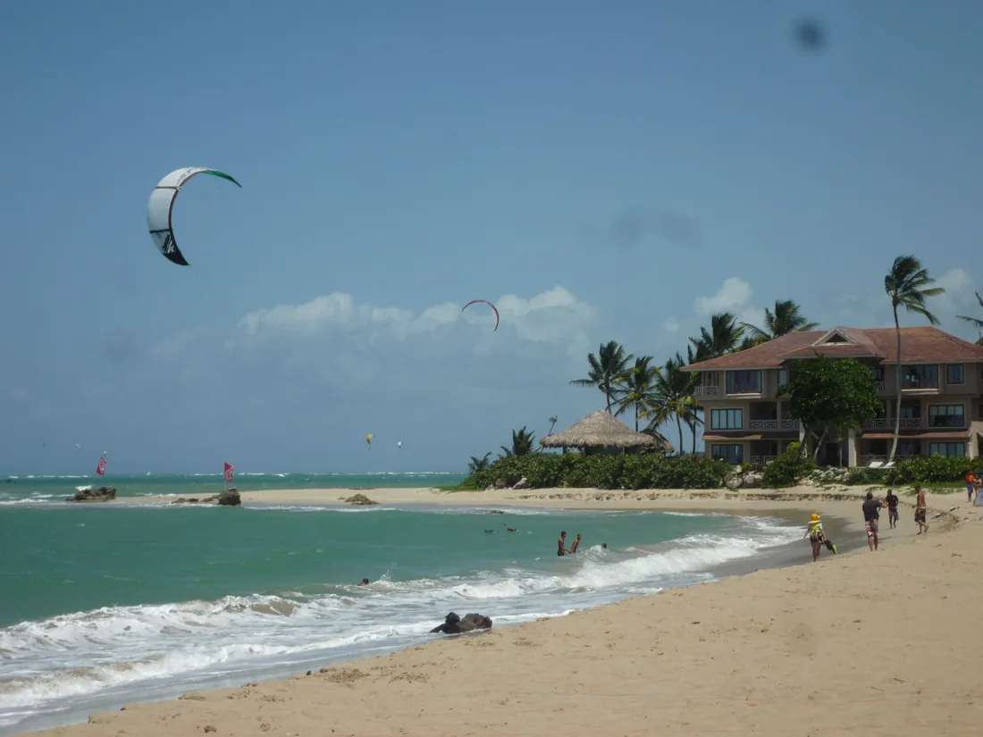Ailes de kite au-dessus du lagon de Kite Beach à Cabarete, paillote et villa sous les cocotiers