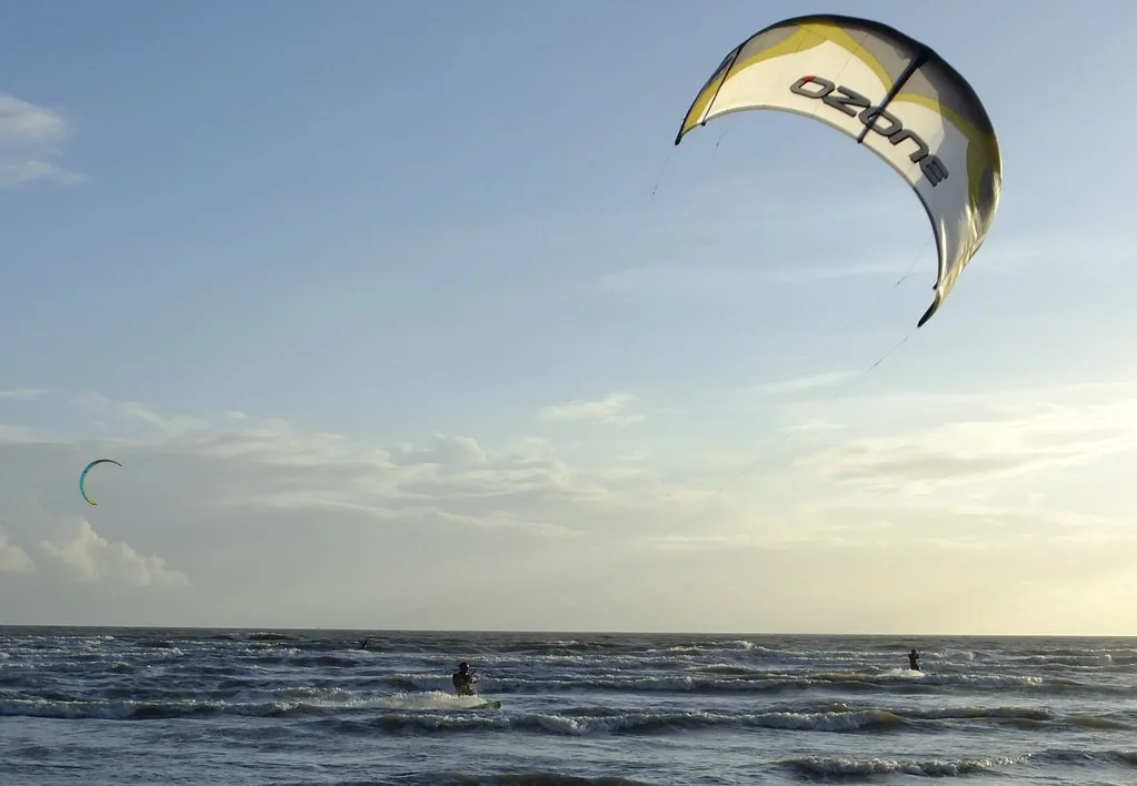 A kitesurfer riding under a large kite off Camber Sands, East Sussex, with a second kite further out to sea