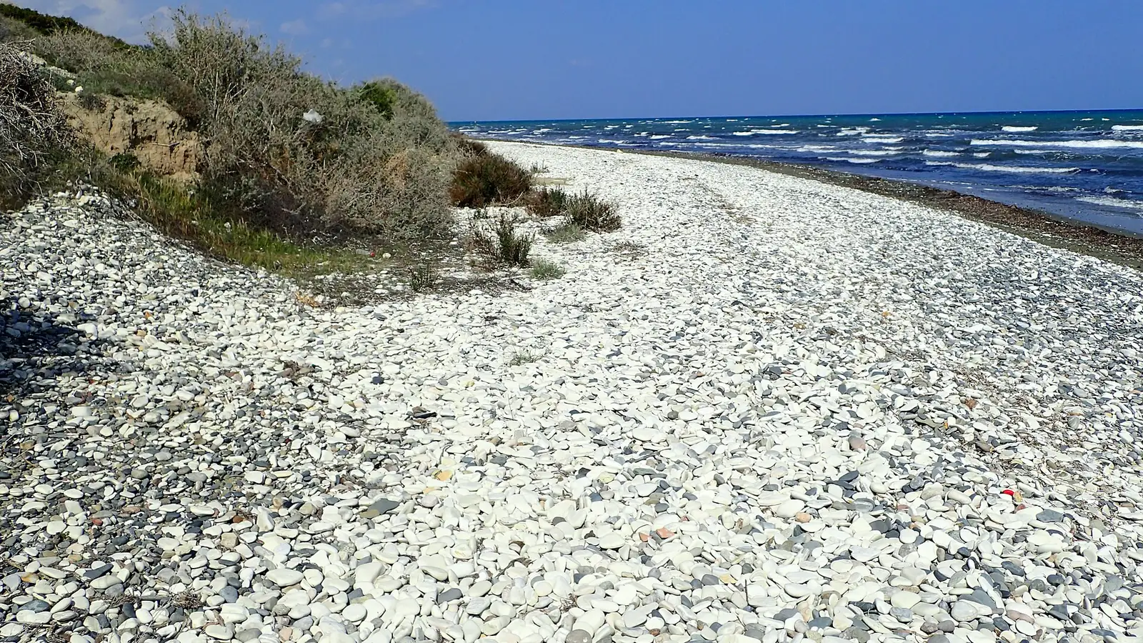 White pebble shore at Cape Kiti, Larnaca District, Cyprus, with whitecaps on the sea