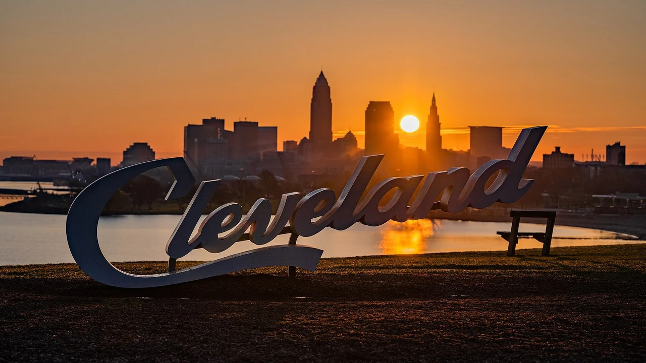 The Cleveland sign at Edgewater Park, Lake Erie, silhouetted against the downtown Cleveland skyline at sunrise