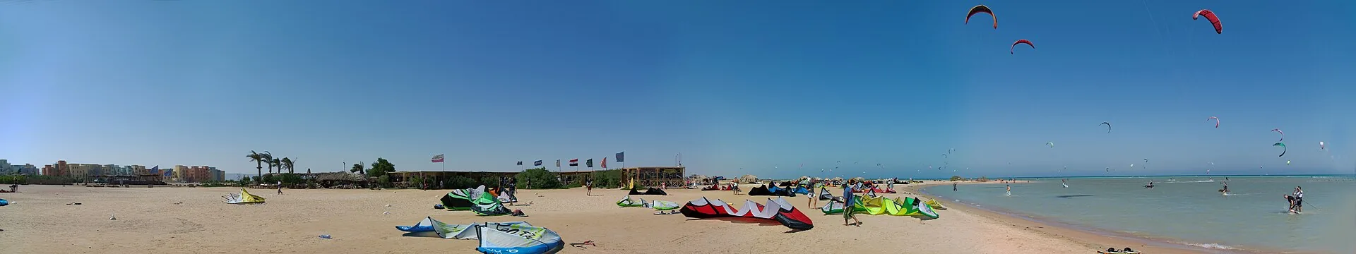 Panorama of Mangroovy Beach, El Gouna, with kites laid out on the sand and kitesurfers in the shallow lagoon