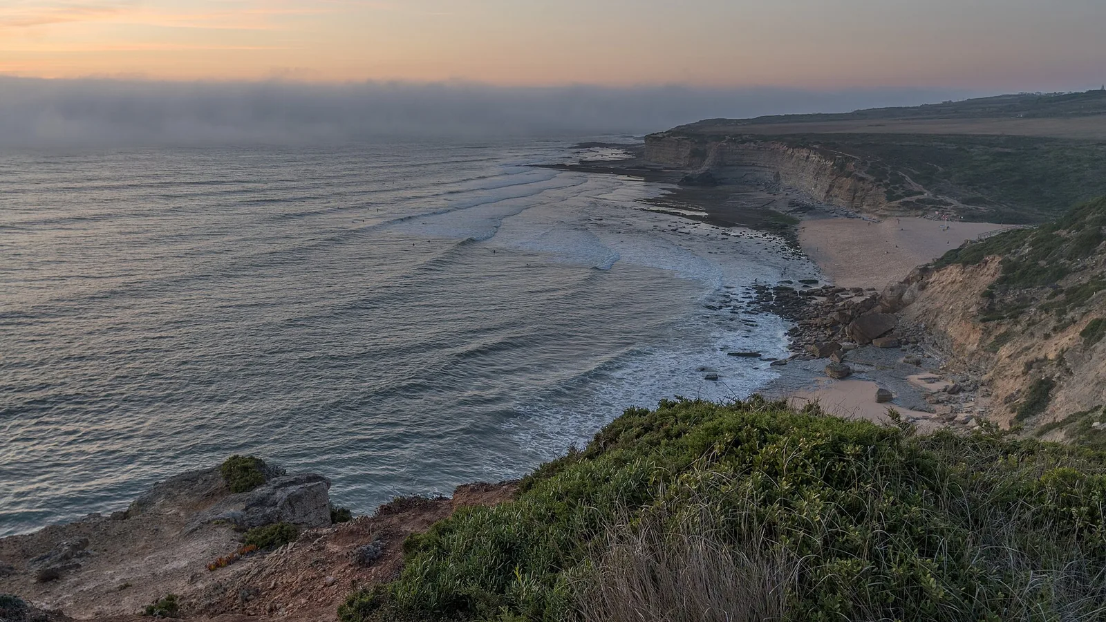 Waves breaking at Praia de Ribeira d'Ilhas, Ericeira, Portugal, at dusk