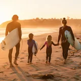 Familia con niños practicando surf en la playa