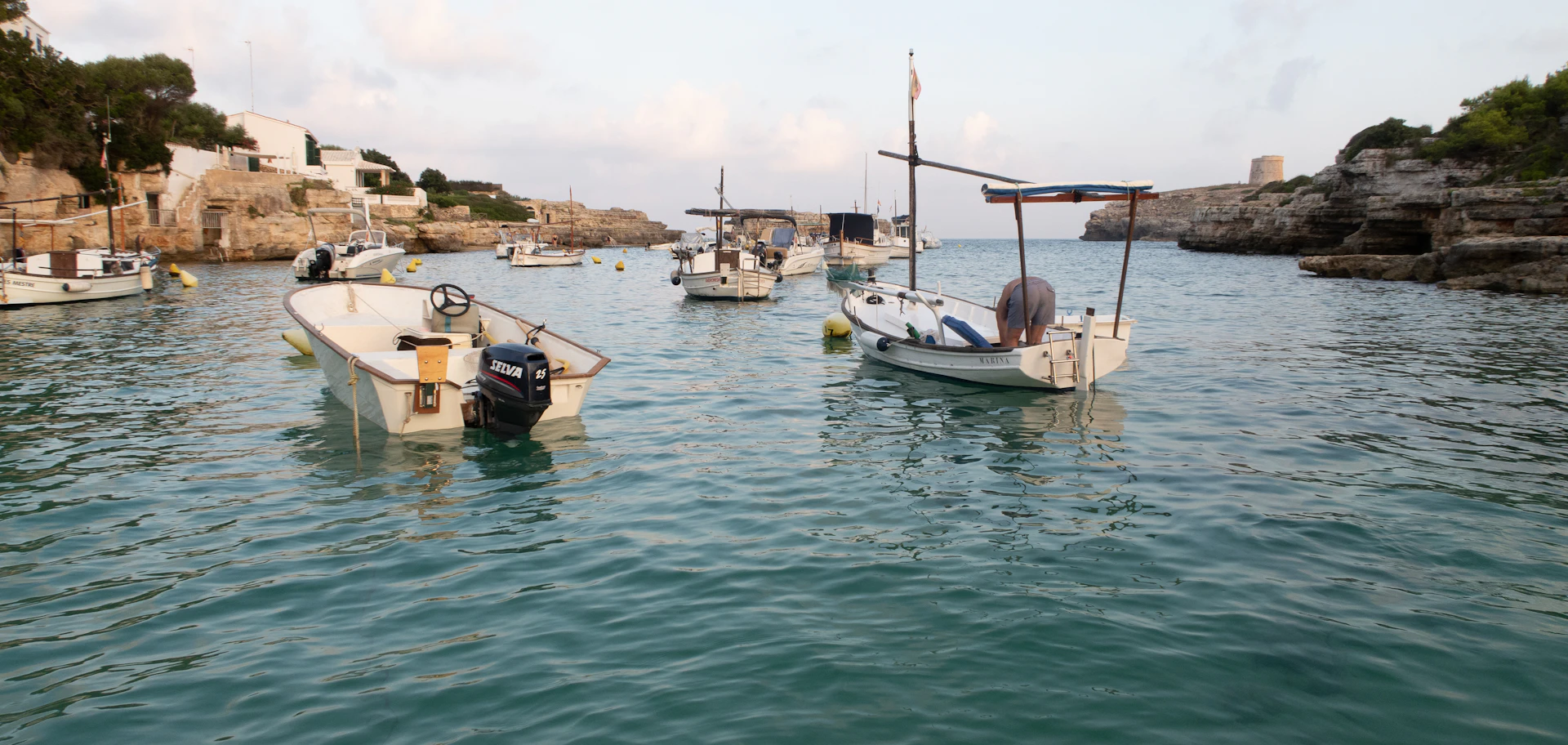 Barcas de pesca fondeadas en una cala tranquila de la costa de Menorca