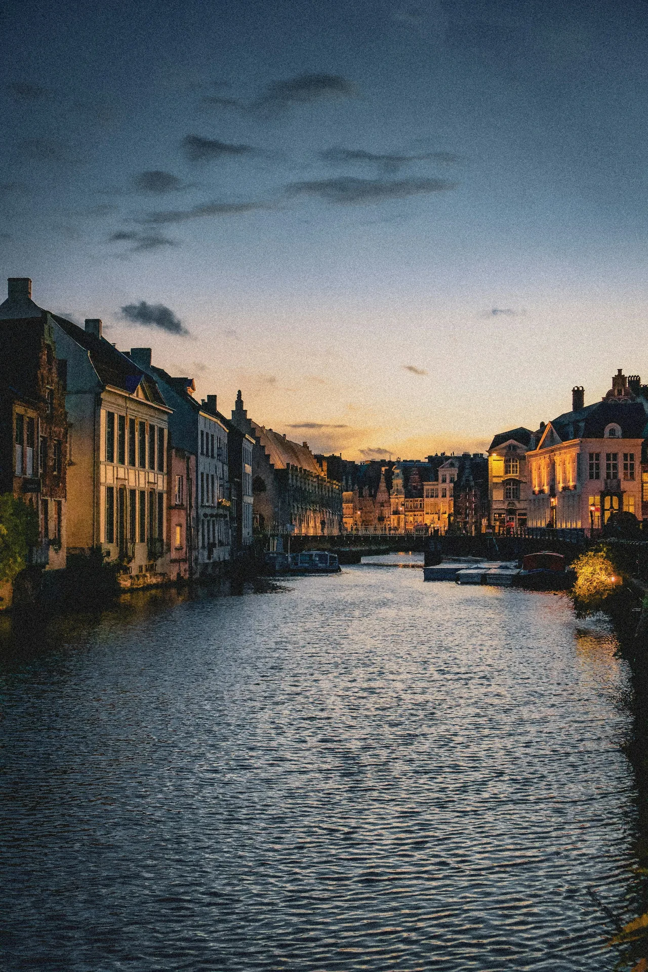 Vue au crépuscule sur un canal de Gand, bordé de maisons de guilde et de péniches