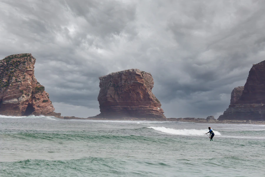Surfeur près des rochers caractéristiques de la côte basque, à proximité de Guéthary