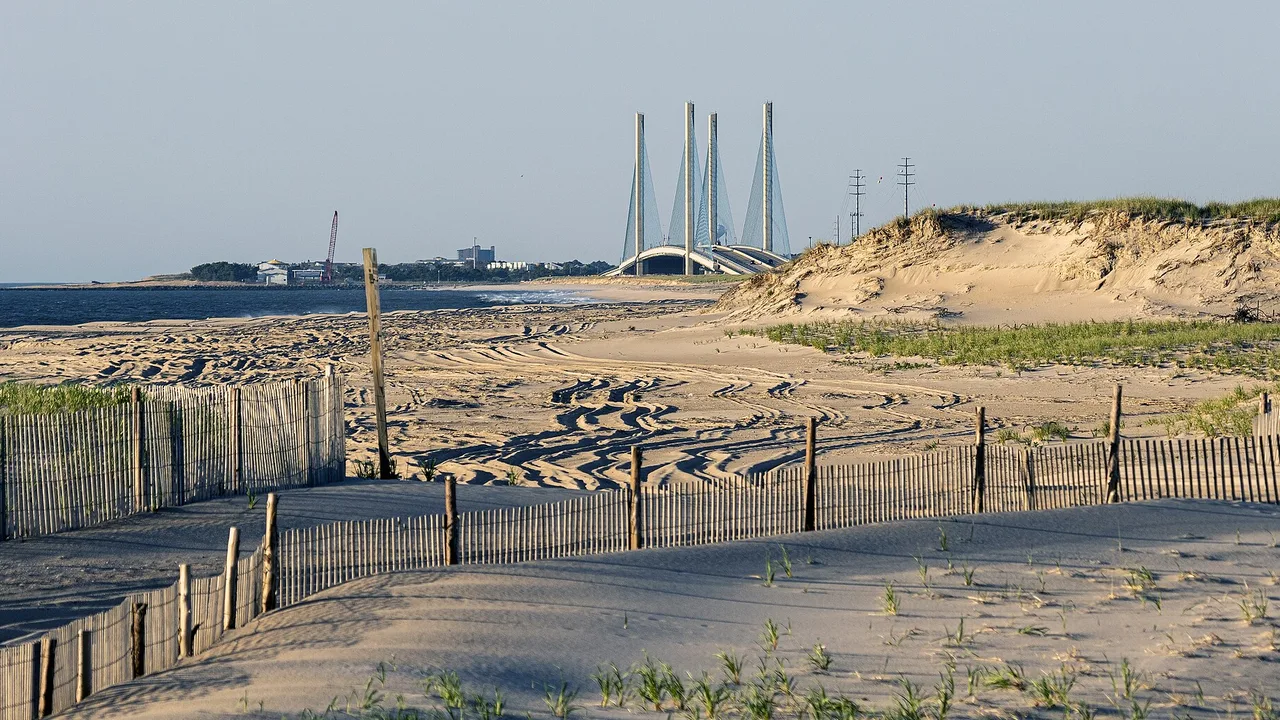Indian River Inlet and its bridge seen from the dunes at Delaware Seashore State Park, Delaware, with breaking waves at the inlet mouth