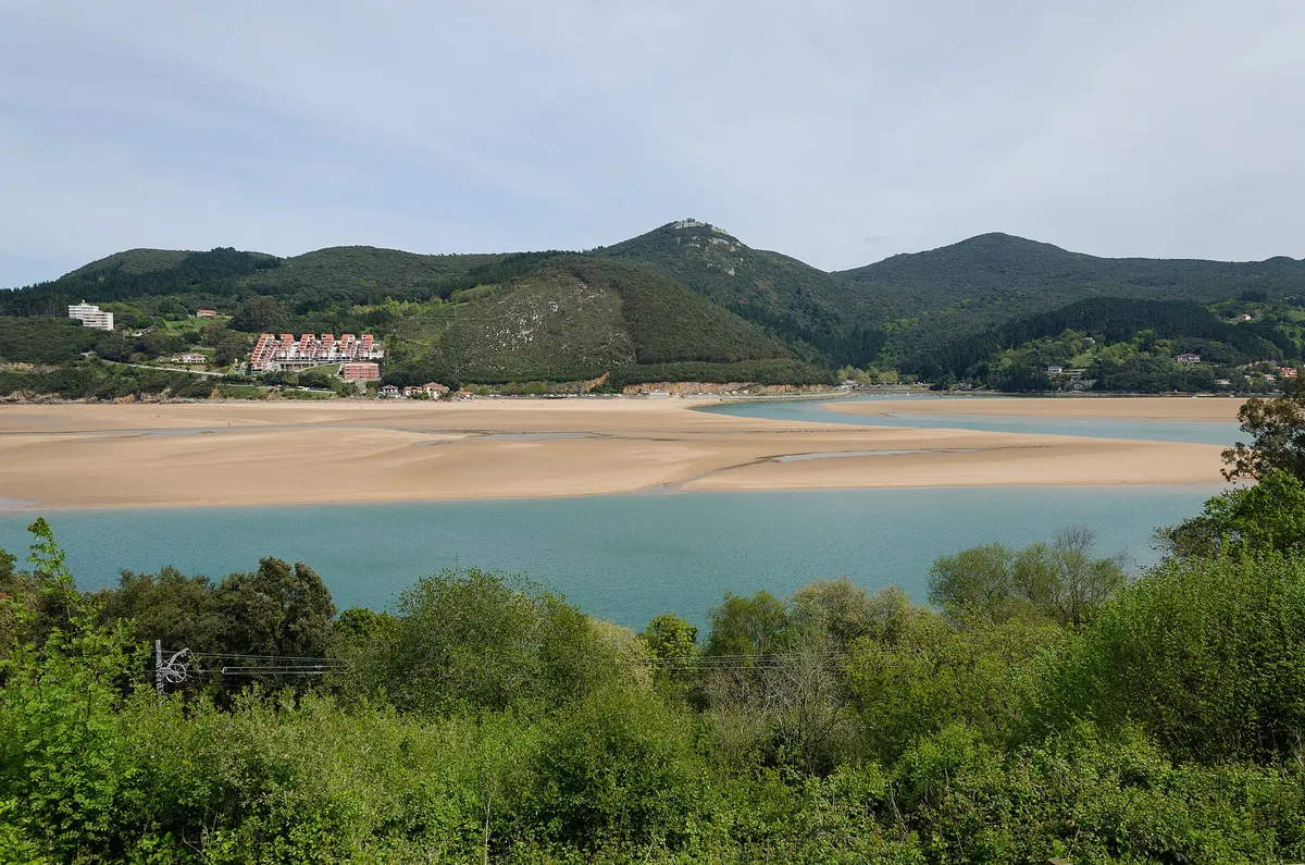 Plage de Laida, avec l'estuaire et des collines vertes au fond