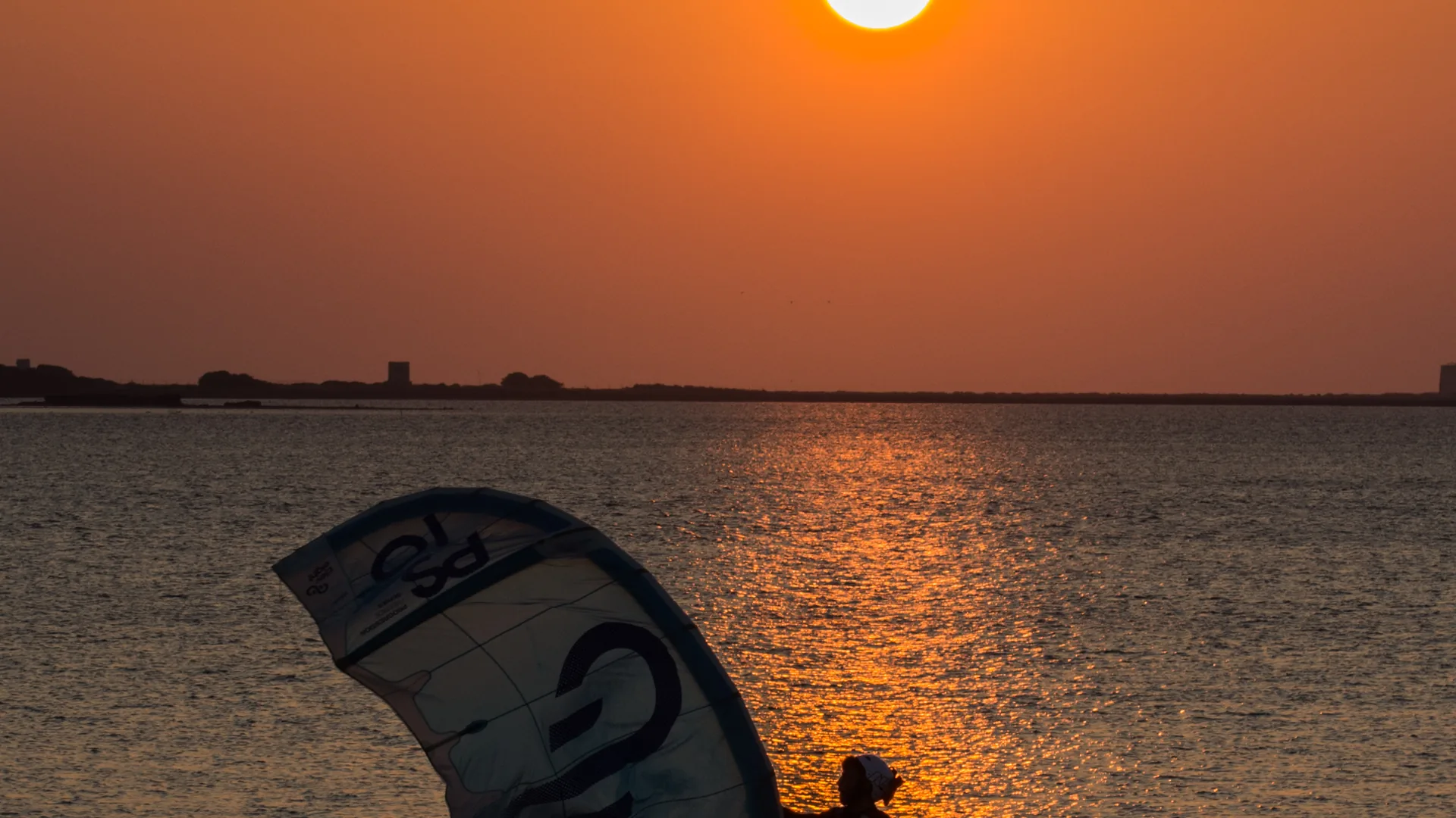Kitesurfeur au coucher du soleil dans la lagune de Lo Stagnone, près de Marsala en Sicile