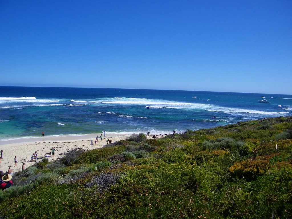 Spectators on the beach and dunes at Surfers Point, Margaret River, with waves breaking on the reef offshore