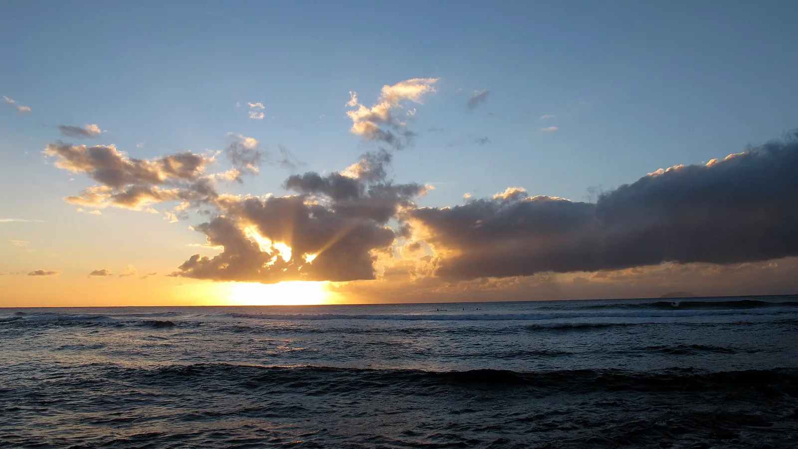 Sunset over the reef at Maria's Beach, Rincón, Puerto Rico, with surfers out on the line-up