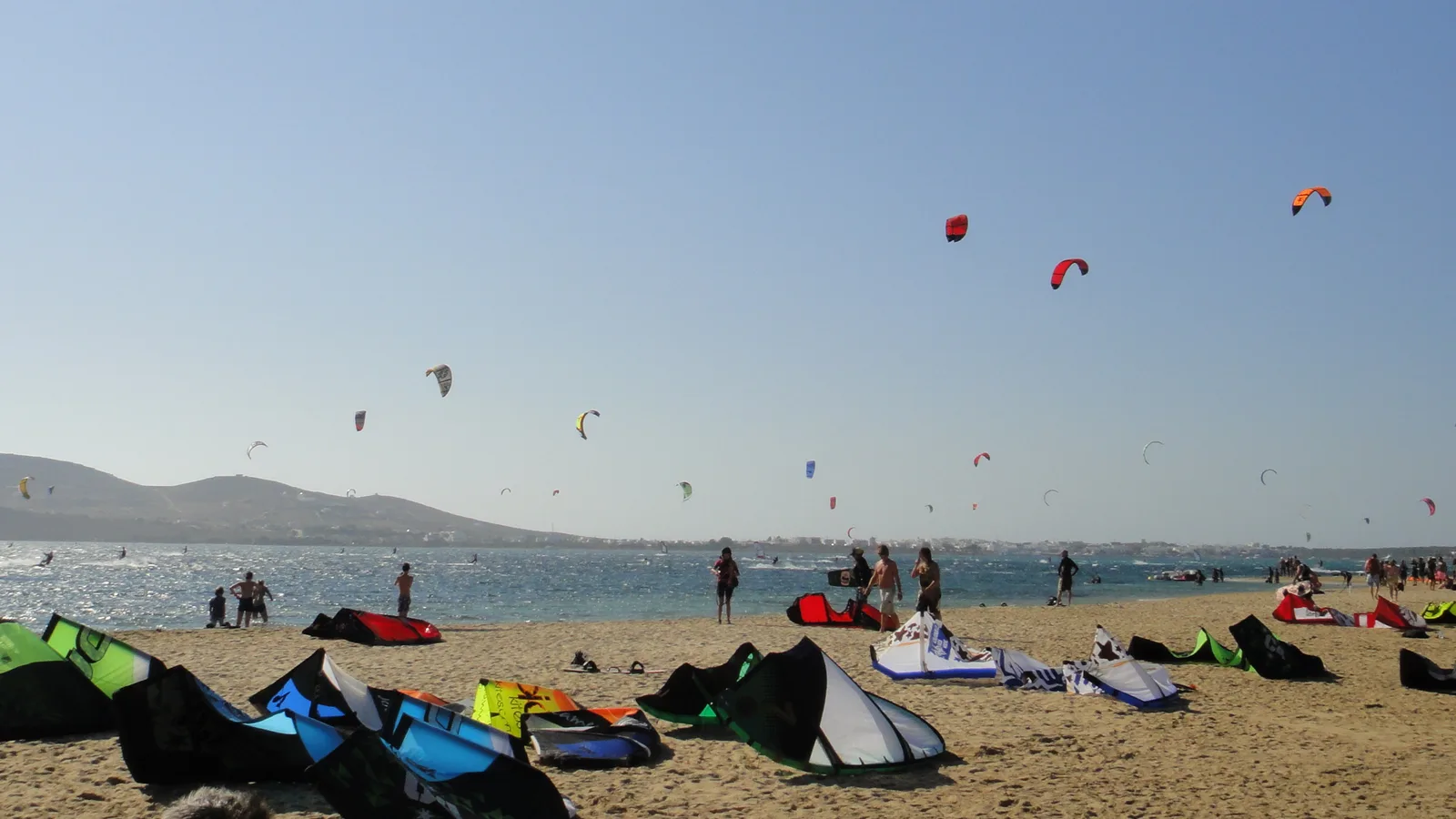 Kites in the air and kites laid out on the beach on Paros, Cyclades, Greece