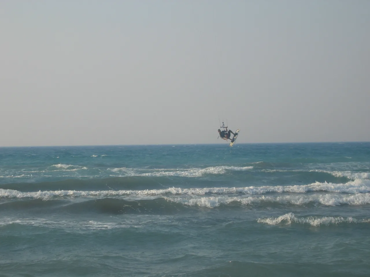 A kitesurfer jumping above breaking waves at Pırlanta Beach, Çeşme