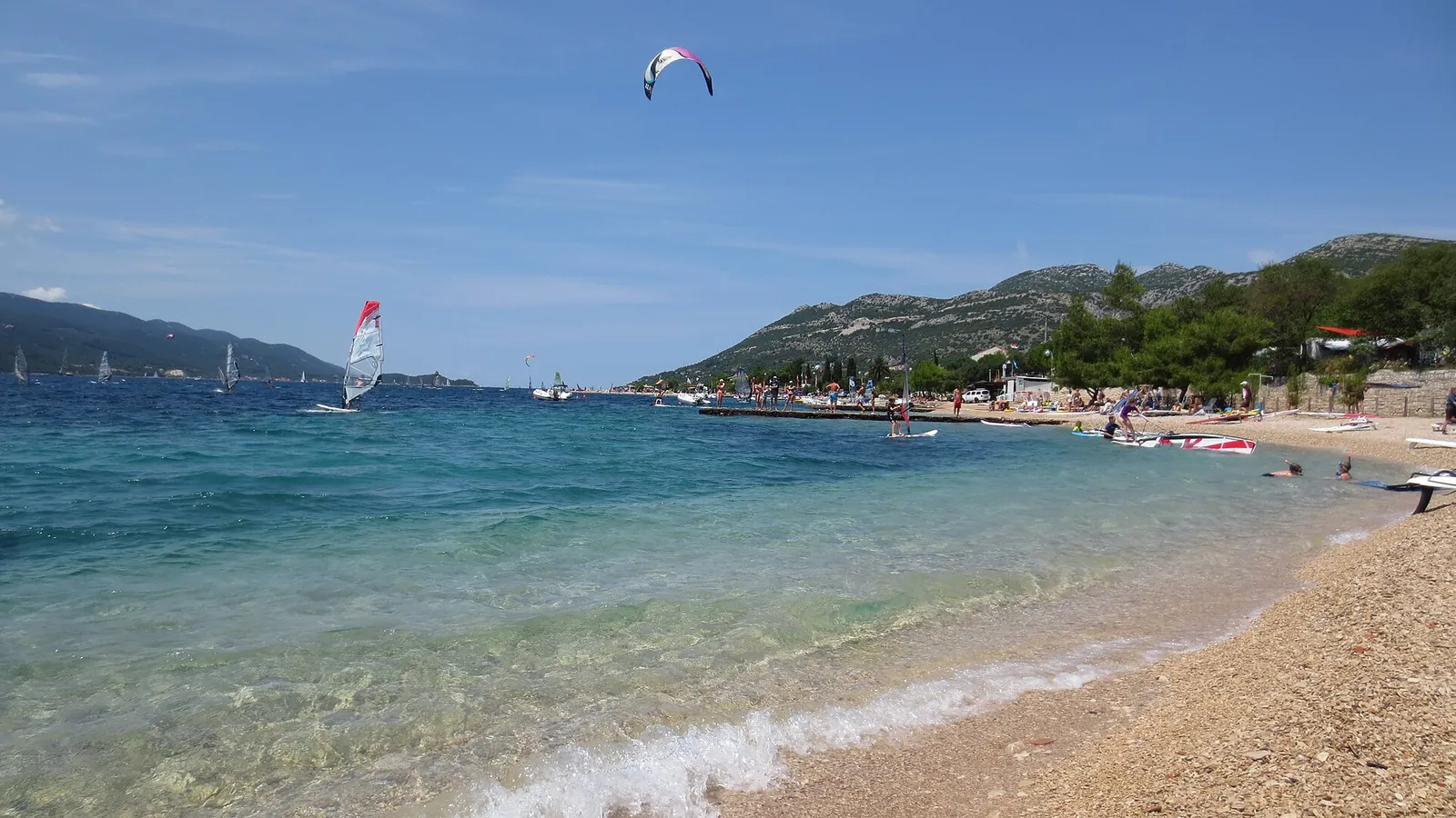 Planches à voile et kitesurf devant la plage de galets de Viganj, sur la péninsule de Pelješac, Croatie