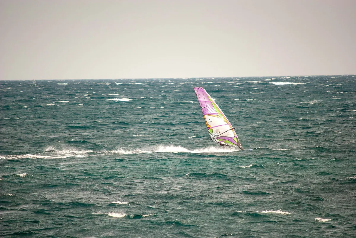 Windsurfeur sur une mer agitée avec des moutons d'écume