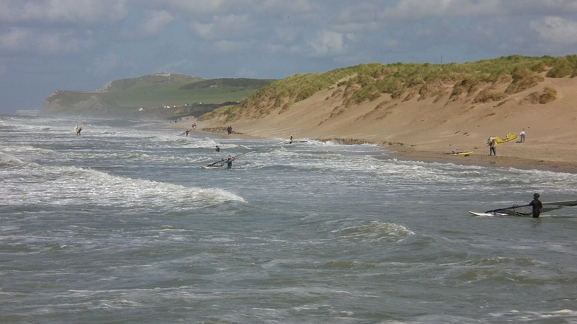 Véliplanchistes dans les vagues à Wissant, avec le Cap Blanc-Nez en arrière-plan